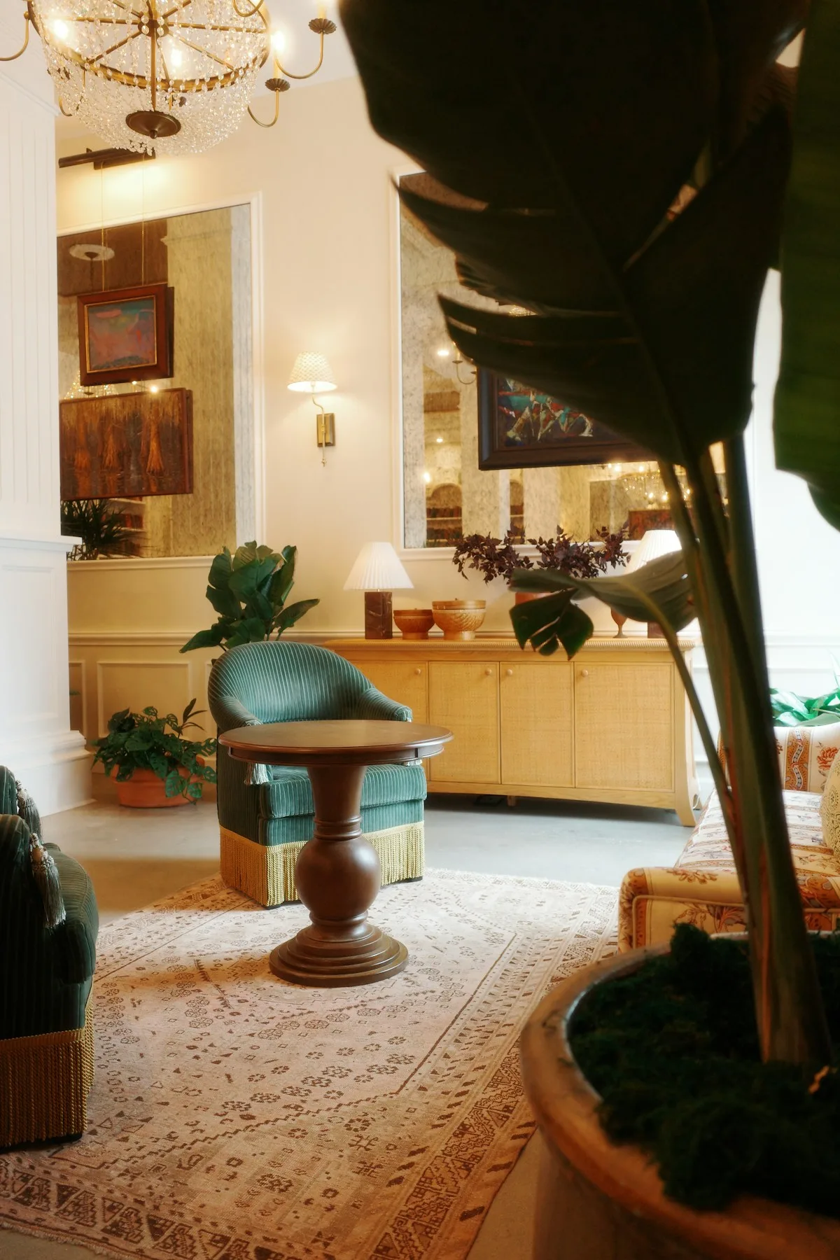 A welcoming hotel lounge with timber furniture and green armchairs